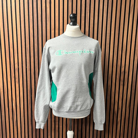 Gray sweater on a mannequin against a wooden slat background made at TMS