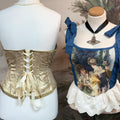 Two mannequins wearing vintage-style corsets with intricate details.