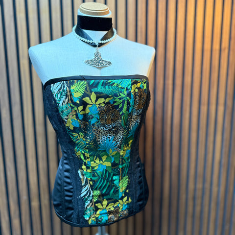 Mannequin wearing a floral and animal print top against a striped background