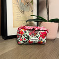 Floral-patterned pouch on a wooden surface with a framed picture in the background made at TMS
