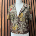 Floral and zebra patterned shirt on a mannequin against a wooden slat background made at TMS