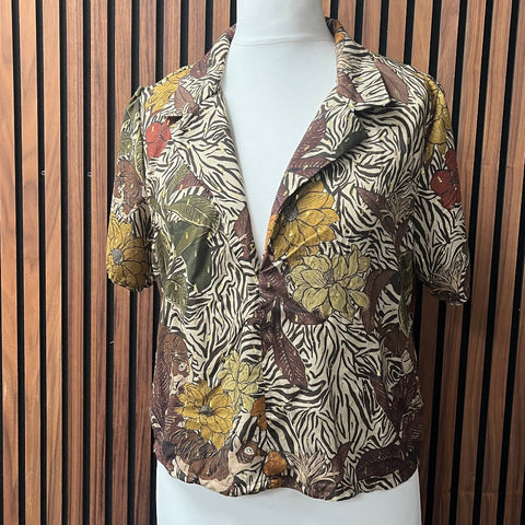 Floral and zebra patterned shirt on a mannequin against a wooden slat background made at TMS